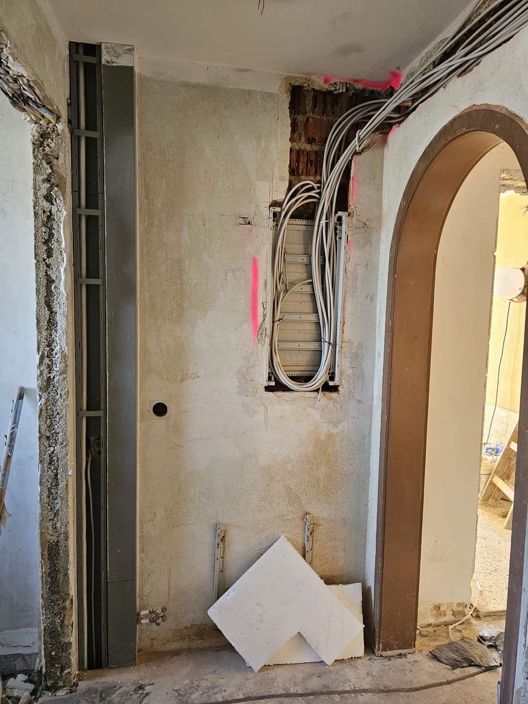 Neues Verteilergehäuse in der Wand, die Zuleitungen sind von oben eingezogen und zunächst aufgerollt.
